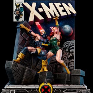 May include: A detailed X-Men statue featuring Cyclops with a red optic blast and Jean Grey as Phoenix. The statue has a dark blue background with the X-Men logo and the text "Phoenix Must Die!". The base has the X-Men logo.