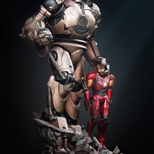 Può includere: Una scultura dettagliata di due figure di Iron Man. La figura più grande è color bronzo con intricati dettagli meccanici, mentre la figura più piccola è rossa e oro. La base presenta la scritta "Iron Man".