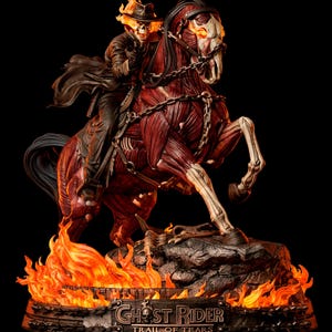 Può includere: Una statua da collezione dettagliata di Ghost Rider che cavalca un cavallo muscoloso e scorticato con occhi arancioni luminosi. La figura indossa un cappotto e un cappello scuri con una testa a teschio fiammeggiante. La base presenta fiamme arancioni e una targa con GHOST RIDER TRAIL OF TEARS.