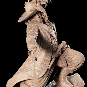 Può includere: Scultura dettagliata di un uomo in abiti storici, in posa dinamica con una spada. La figura indossa un cappello a tesa larga ornato di piume, un lungo cappotto e stivali. La scultura è di colore beige monocromatico, su sfondo nero.