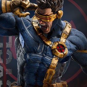 May include: A detailed statue of a superhero in a blue and gold costume. The figure is in an action pose, with a stern expression and a gold visor. The costume has intricate details and a textured appearance.
