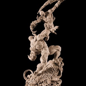 Puede incluir: Escultura beige de una escena de batalla con dos figuras. Una figura salta con los brazos extendidos, la otra agachada debajo. La base presenta el texto "VENOM CARNAGE" y detalles intrincados.