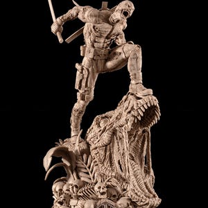 Puede incluir: Estatua beige detallada de un personaje en una pose dinámica, sosteniendo una espada y de pie sobre la cabeza de un monstruo. La base presenta calaveras y un símbolo. La figura es muy detallada con texturas y accesorios visibles.