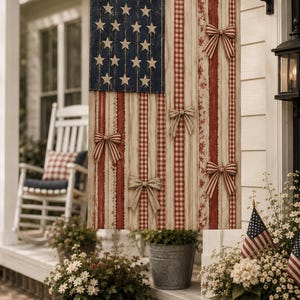 May include: A vertical decorative flag featuring a blue canton with white stars and vertical stripes in red and white patterns. The flag is embellished with five fabric bows attached to the stripes. It hangs from a horizontal metal pole.