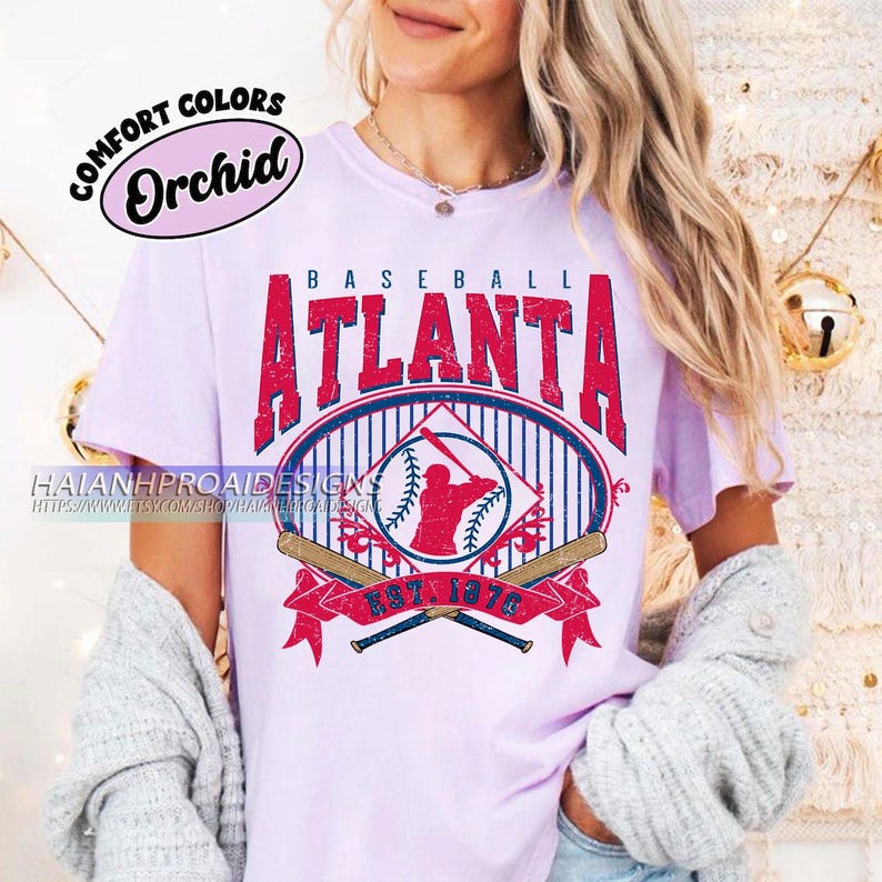 May include: A purple t-shirt with a vintage baseball graphic. The graphic features the text "Baseball Atlanta Est. 1876" with a baseball player silhouette and crossed bats.