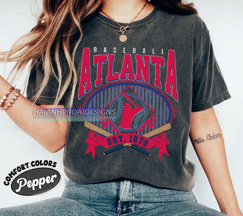 May include: A gray t-shirt with a vintage baseball graphic featuring the text "BASEBALL ATLANTA EST. 1876". The graphic is in red, blue, and white with a baseball player silhouette.