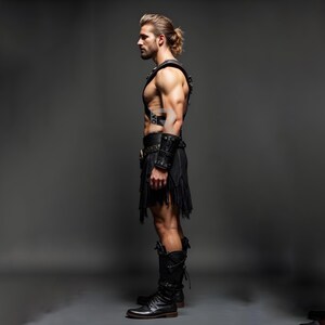 May include: A man wearing a black leather kilt, a black leather harness, and black leather boots. He is standing with his arms at his side and looking to the left.