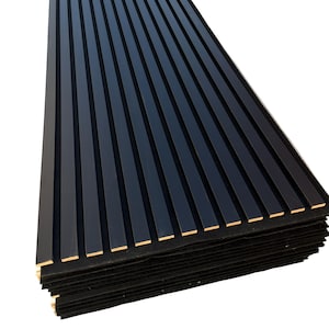May include: A stack of black wooden slat panels. Each panel has a series of vertical, evenly spaced, black wooden slats. The panels are stacked on top of each other, revealing the natural wood color on the edges. The background is white.