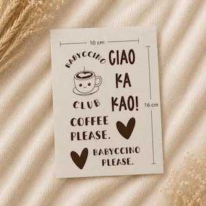 May include: A rectangular off-white card featuring dark brown text and graphics. The card displays the text Babyccino Club, Ciao Ka Kao!, Coffee Please., and Babyccino Please., along with a smiling coffee cup and two hearts. It measures 10 cm by 16 cm.