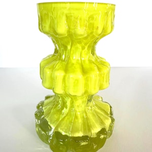 May include: A bright yellow glass vase with a textured, rippled surface. The vase has a wide mouth and a narrow base.