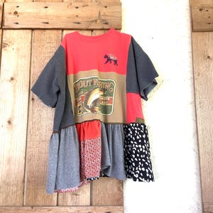 Peut inclure: Une robe en patchwork rouge, gris et noir avec un ourlet à volants. La robe présente un patch de pêche à la truite de style vintage avec le texte "Trout Fishing" et un graphique d'ours.