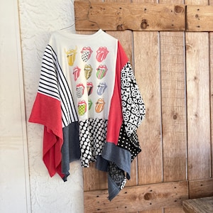 Könnte beinhalten: Ein Patchwork-Oberteil mit einer Vielzahl von Mustern und Farben. Das Oberteil hat eine weiße Basis mit mehreren Rolling Stones Zungen-Logos. Die Ärmel sind rot, schwarz-weiß gestreift, schwarz-weiß gepunktet und schwarz-weiß gemustert.