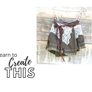 May include: A brown skirt with a white lace overlay and a burgundy ribbon tied around the waist. The skirt is hanging on a wooden hanger.