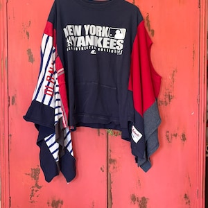 Könnte beinhalten: Ein marineblaues und rotes Patchwork-Oberteil mit dem Text "NEW YORK YANKEES" in Weiß. Das Oberteil hat eine Tasche und besteht aus wiederverwerteten T-Shirts. Die Ärmel sind eine Mischung aus rot-weiß-gestreiftem Stoff.