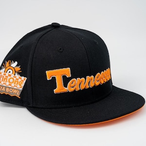 May include: Black baseball cap with the word "Tennessee" in orange script across the front. The cap has an orange brim and a patch on the side with the words "All in One Fiesta Bowl".