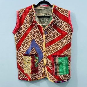 Könnte beinhalten: Eine wendbare Weste ohne Ärmel mit Patchwork-Design. Die Weste hat einen roten Hintergrund mit braunen und weißen Mustern, blauen und gelben Akzenten und zwei Taschen. Der Text "Marajas Craft" ist auf der Weste zu sehen.