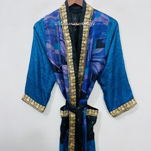 May include: A blue and black silk robe with gold trim and a matching belt. The robe has a paisley pattern and the text "Maharajas Craft" is visible on the collar.