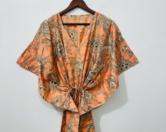 Peut inclure: Une kaftan de couleur pêche avec un imprimé floral et une ceinture à nouer à la taille.