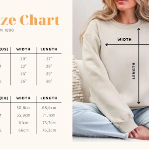 May include: A size chart for a Gildan 1800 sweatshirt, with measurements in inches and centimeters. The chart shows the width and length for sizes S, M, L, and XL. The image also shows a person wearing a beige sweatshirt.