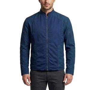 May include: A dark blue zip-up jacket featuring a stand-up collar, long sleeves with zippered utility pockets on the upper arms, and a central full-length silver zipper. The garment is constructed with a textured front panel and solid sleeves.