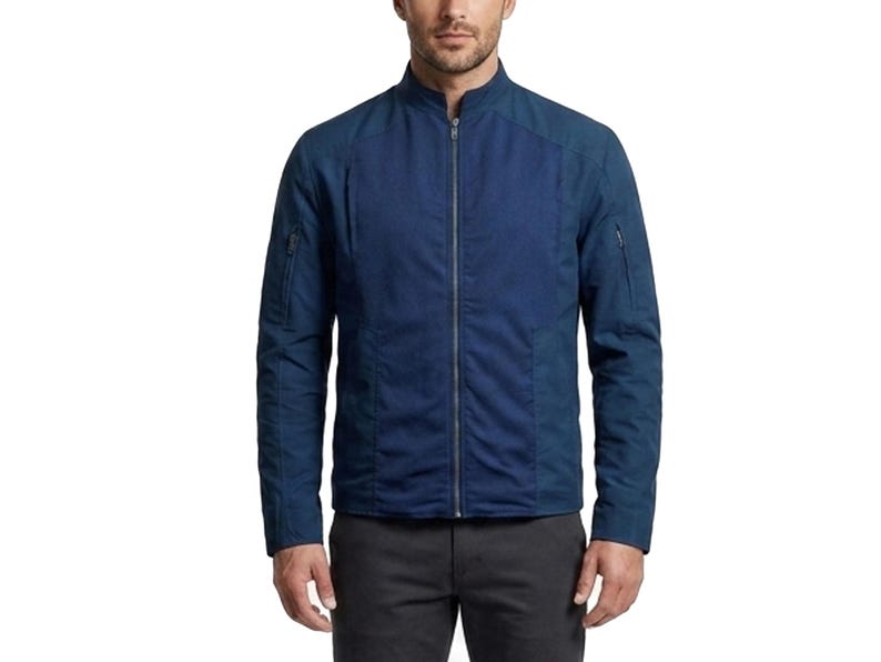 May include: A dark blue zip-up jacket featuring a stand-up collar, long sleeves with zippered utility pockets on the upper arms, and a central full-length silver zipper. The garment is constructed with a textured front panel and solid sleeves.