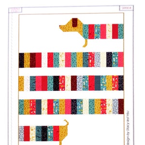 May include: A quilting pattern for a 45-inch by 60-inch quilt featuring a dachshund made of colorful fabric squares. The pattern is titled "All Wrapped Up" and is designed by Stacy Iest Hsu. The pattern uses the fabric line "Woof Woof Meow Meow" from Moda.