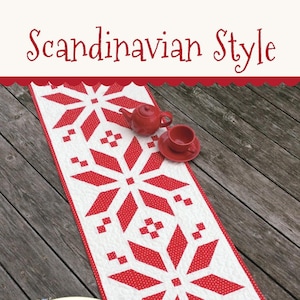 May include: Red and white quilted table runner with a Scandinavian snowflake design. The runner is on a wooden surface with a red teapot and teacup. The text "This & That" and "Original Quilt Patterns by Sherri K. Falls" is on the runner. The number "#312" is in the bottom right corner.