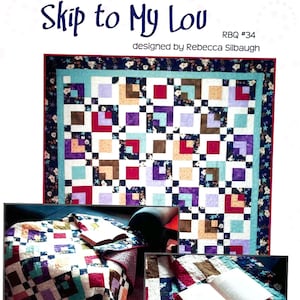 May include: A quilt pattern called "Skip to My Lou" designed by Rebecca Silbaugh. The quilt is made of colourful squares in shades of red, purple, blue, brown, and beige. The quilt is shown on a sofa with a book on top of it.
