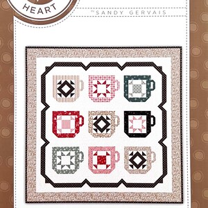 May include: A quilt pattern featuring nine patchwork mugs in various colors and patterns. The design includes a decorative border and the text "Mug Collection" and "Pieces From My Heart."
