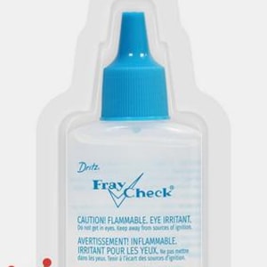 May include: Dritz Fray Check liquid seam sealant in a clear plastic bottle with a blue cap, packaged on a white card. The label reads Fray Check, Liquid Seam Sealant, Stops Fraying on Fabric, and 0.75 FL OZ (22 ml) with safety warnings.