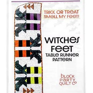 May include: A sewing pattern for a Witches Feet table runner in a clear plastic bag. The cover features a graphic of a quilted runner with black, orange, purple, and lime green striped blocks on a white spiderweb background and text.