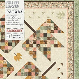 May include: A quilt pattern named "Fallen Leaves" with a design of stylised leaves in shades of brown, pink, and green. The quilt has a cream background and a decorative border. The pattern is by Natalie Crabtree for BasicGrey.
