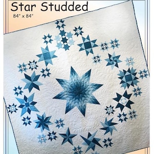 May include: A white quilt titled Star Studded measuring 84" x 84" featuring a central large blue star surrounded by smaller blue and white star patterns. The fabric has a quilted texture and the text EUQ318 and ErinUnderwoodQuilts.com are visible.