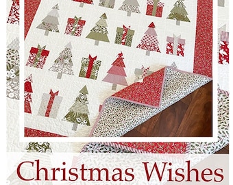 May include: A Christmas-themed quilt featuring a repeating pattern of Christmas trees and gift boxes in shades of red, green, and gray on a white background. The quilt has a red border and the text "Christmas Wishes".