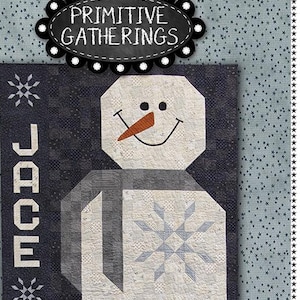 May include: A quilt pattern featuring a snowman with the name "Jace" in large letters. The quilt is made in a blue and white color scheme with a snowflake design. The finished size of the quilt is 57 inches by 72 1/2 inches.