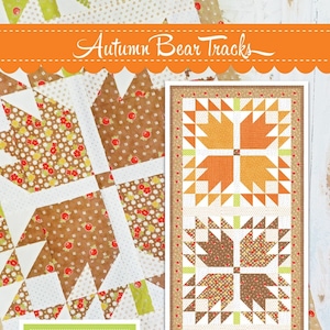 May include: A quilting pattern for a table runner featuring a bear paw design in orange, brown, and green fabrics. The pattern is called "Autumn Bear Tracks" and is from Fig Tree & Co.