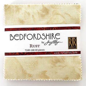May include: A pack of 40 fabric squares in a rust color with a white and brown marbled pattern. The fabric squares are labeled "Bedfordshire by Jinny Beyer, Rust, 7100-168 40 pieces, www.rjrfabrics.com".