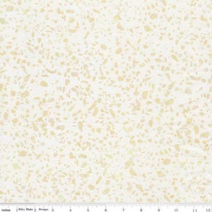 May include: Cream-colored fabric with a speckled pattern of irregular shapes in shades of beige and light yellow. The fabric has a subtle texture and a ruler along the bottom edge, marked in inches.
