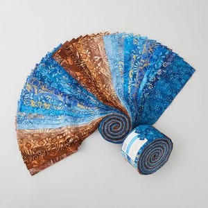 May include: A collection of fabric strips in shades of blue and brown, arranged in a fan shape. The fabric features floral and abstract patterns. A rolled bundle of the fabric is visible at the bottom right, showcasing the fabric's design and texture.