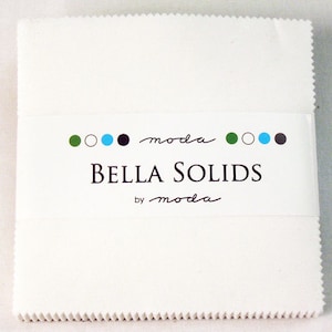 May include: A white fabric square with a label that reads "Bella Solids by moda" with green, white, blue, and black circles.