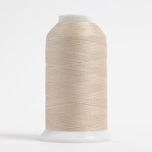 May include: A spool of beige thread, tightly wound and cylindrical, sits on a white base. The thread has a subtle sheen, suggesting a smooth texture. Ideal for sewing, embroidery, or other textile crafts.