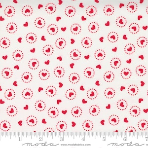 May include: White fabric with a repeating pattern of red hearts and red circles with white dots. The fabric has a ruler with inches marked along the bottom.