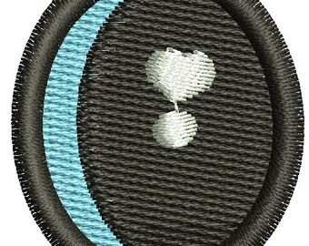 May include: Embroidered patch with a black border and a textured gray background. A light blue crescent shape is on the left side. A white heart shape and a white sphere are in the center.