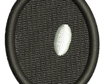 May include: Embroidered patch featuring a black oval with a textured background and a white, oval-shaped design element. The patch has a thick, black border, and the design is likely for apparel or accessories.