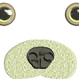 Könnte beinhalten: Gesticktes Design eines Cartoon-Tiergesichts mit zwei runden Augen mit weißen Glanzlichtern und einer dunklen Nase. Die Augen haben einen braunen Rand mit einem gelben Innenring. Die Nase ist dunkelgrau und das Gesicht hat einen hellgrünen Rand.