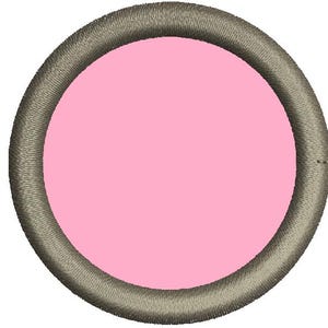 Puede incluir: Un parche bordado circular con un centro rosa claro y un borde gris. El borde tiene una apariencia texturizada y cosida. El parche tiene una forma simple y redonda.