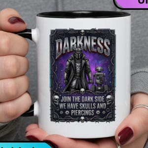 May include: A white mug with a black interior and handle, featuring a graphic with the word "DARKNESS" and an image of a character and a robot. The text "JOIN THE DARK SIDE WE HAVE SKULLS AND PIERCINGS" is also visible. The mug is available in 4 styles.