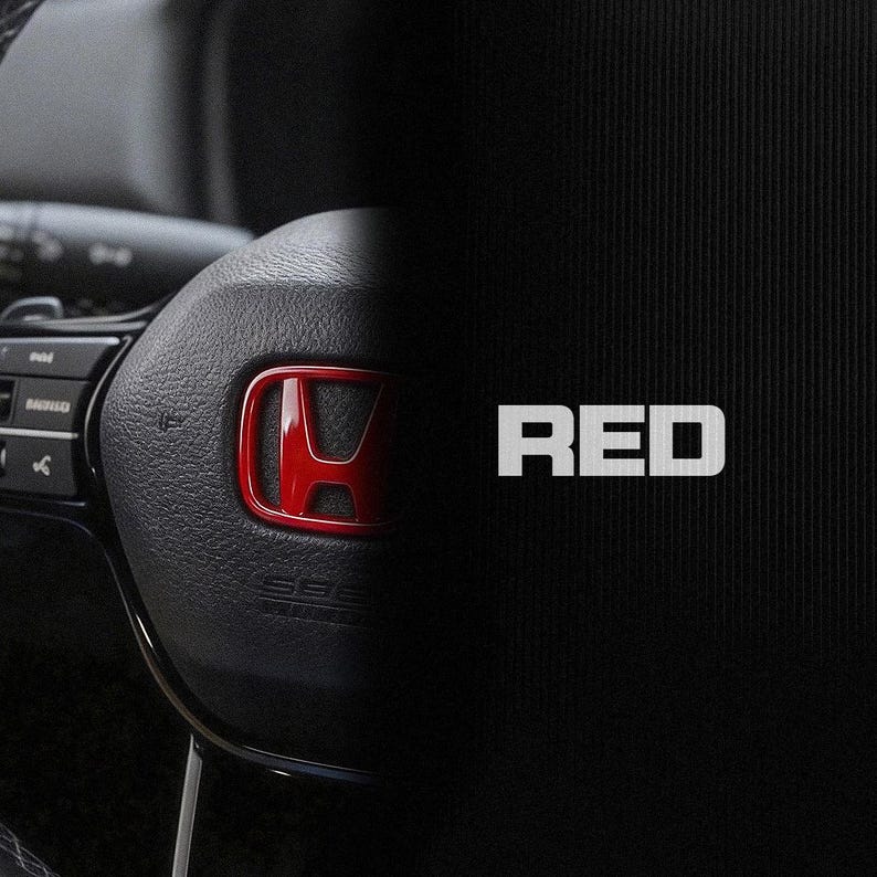May include: A close-up of a black steering wheel with a red Honda emblem. The word "RED" is displayed in white, bold letters on a black background. The image is split diagonally.