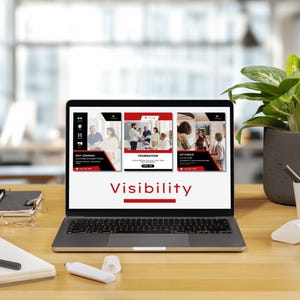 Puede incluir: Un port&aacute;til muestra una presentaci&oacute;n con la palabra "Visibilidad" en texto rojo. La presentaci&oacute;n incluye im&aacute;genes de personas en entornos empresariales. El port&aacute;til est&aacute; sobre un escritorio de madera con material de oficina y una planta en maceta.