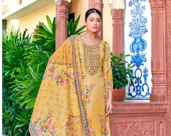 Puede incluir: Conjunto salwar kameez amarillo mostaza con dupatta estampado floral. El conjunto presenta una túnica de manga larga con bordado dorado, pantalones rectos a juego y una bufanda estampada. El atuendo se usa con sandalias.